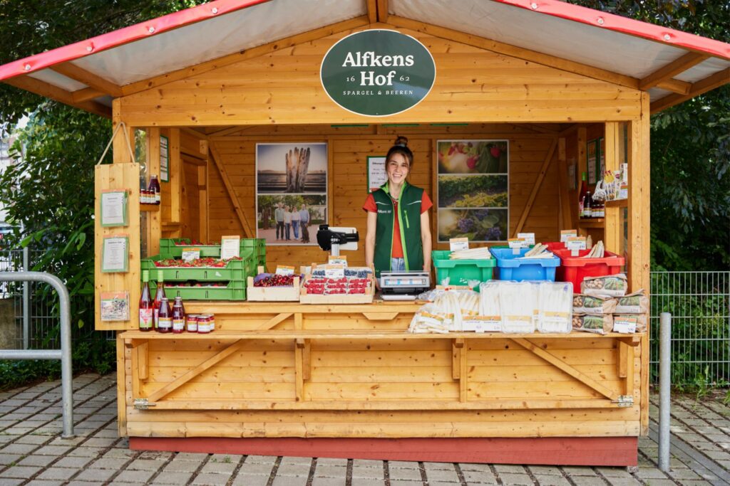 Hofläden Bremen: Verkaufsstand von Alfkens Hof mit einer jungen Frau