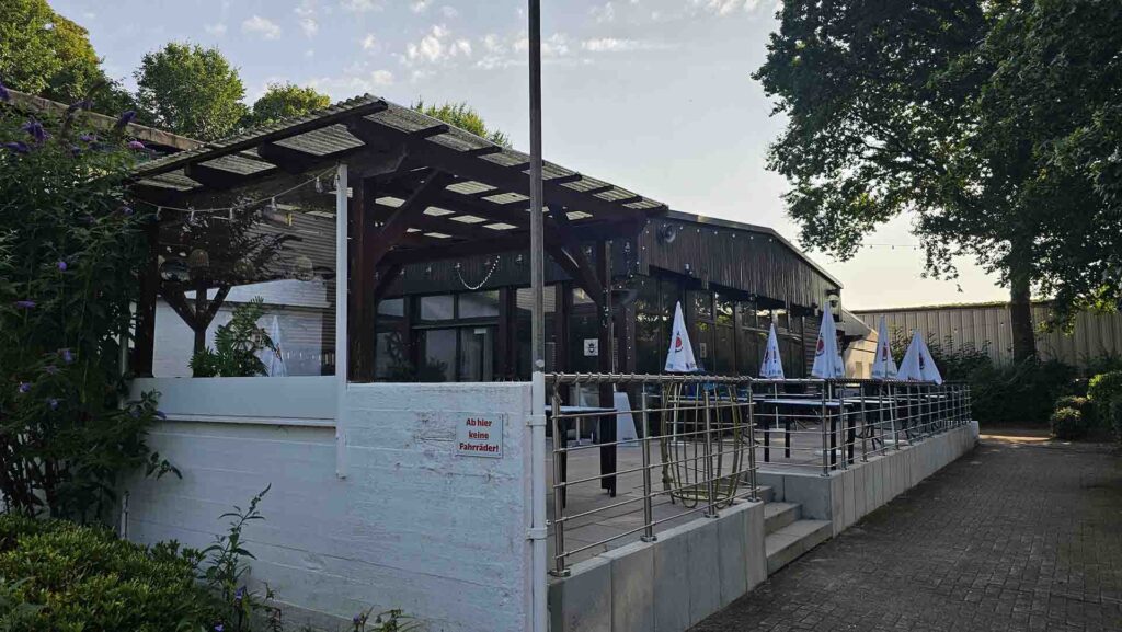 Außenbereich des Restaurants Barkita auf dem Stadtwerder mit Holzüberdachung, Terrasse und Stehtischen