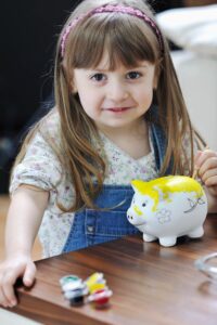 Kids Day Blumenthal: Ein Mädchen bemalt ein Sparschwein