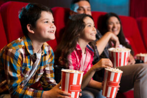 Eine Familie, die im Kino ist mit Fokus auf den beiden Kindern, Symbolbild für das KIJUKO Bremen