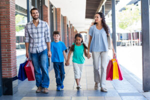 Eine Familie mit zwei Kindern in einem Outlet Center beim Shoppen