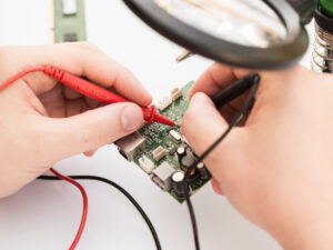 Nahaufnahmen auf Hände, die eine Platine reparieren oder überprüfen